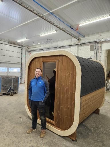 Simon beside a completed sauna inside the Estonian factory
