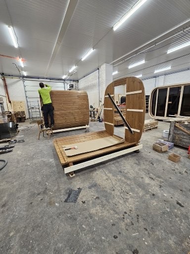 Saunas at different stages of assembly on the production floor