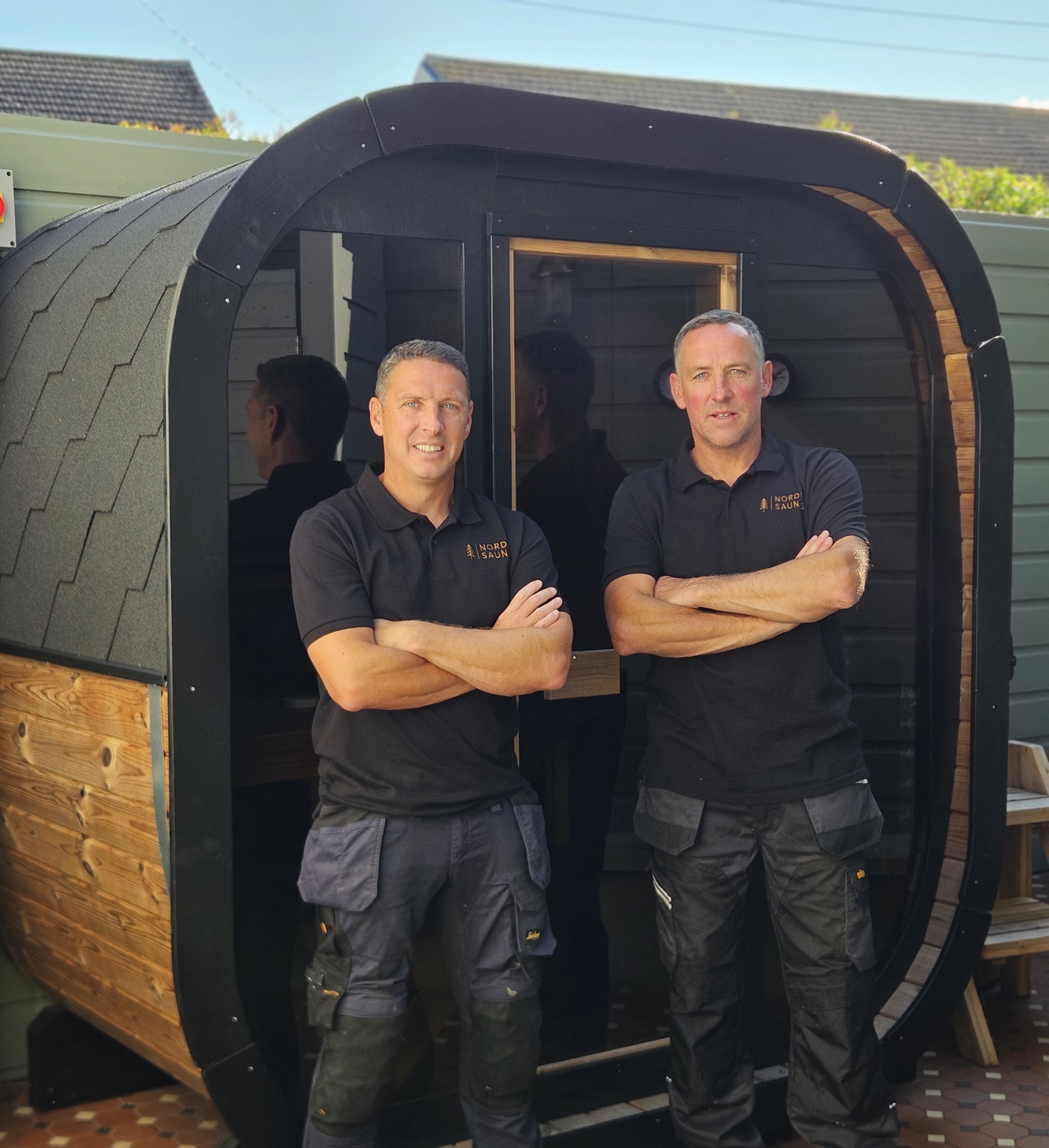 Simon and Jason standing in front of a Nordic Saunas garden sauna